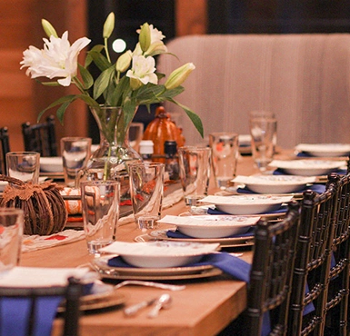 A long wooden table is set for a dinner party.
